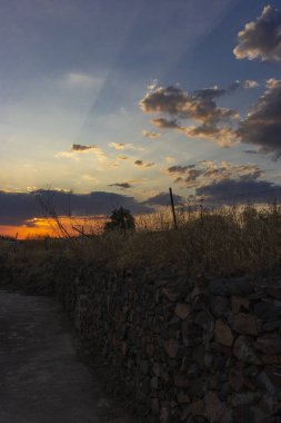 Endülüs 'teki bir tarlada taş duvar İspanya' da günbatımı gökyüzü