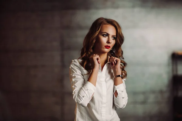 어두운 스튜디오 뒤에 흰 셔츠 를 입은 사업상의 여자, 긴 머리와 붉은 립스틱 을 가진 모델 — 스톡 사진