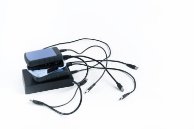 Beyaz arka planda kabloları olan birçok harici sabit disk var. İzole edilmiş sabit diskler