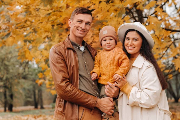 Padre y madre con hijo caminando en el parque de otoño. Una familia camina en el Otoño de Oro en un Parque Natural. —  Fotos de Stock