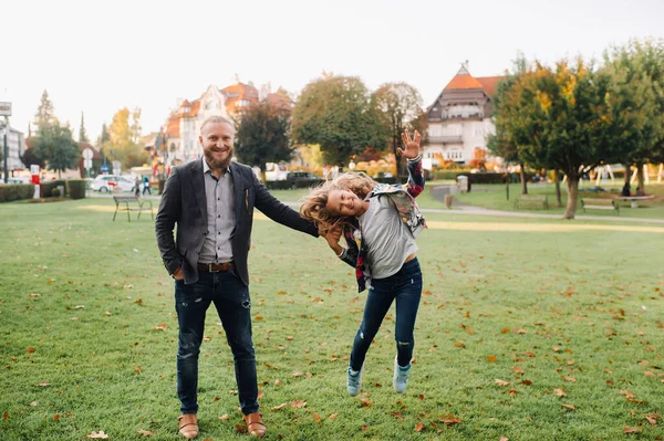 Vater und Tochter laufen auf dem Gras in der Altstadt von Austria.Eine Familie spaziert durch eine Kleinstadt in Austria.Europa.Felden am Werten see — Stockfoto