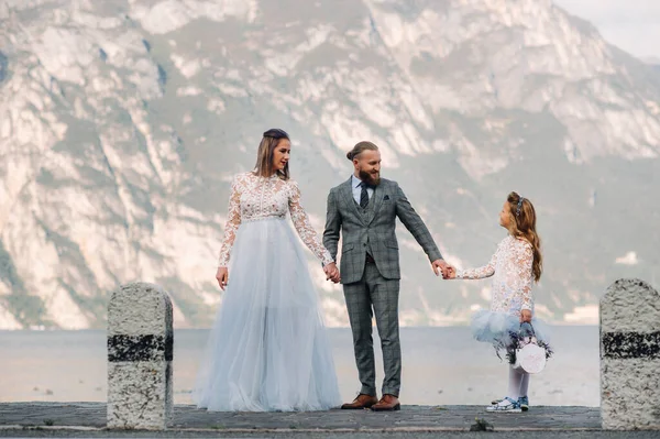 Italien, Gardasjön. Vacker familj vid stranden av Gardasjön i Italien vid foten av Alperna. Far, mor och dotter i Italien — Stockfoto