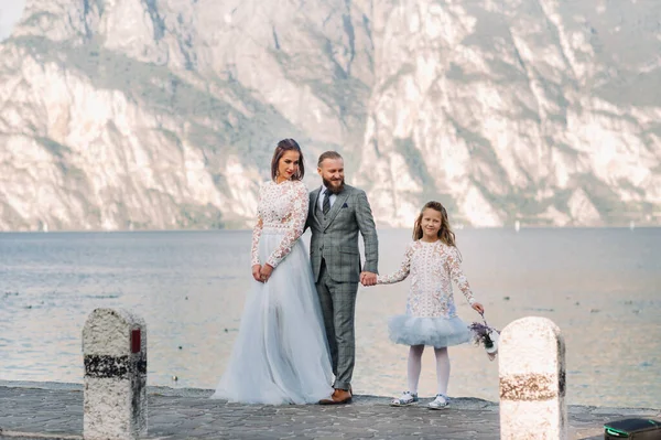 Italien, Gardasjön. Vacker familj vid stranden av Gardasjön i Italien vid foten av Alperna. Far, mor och dotter i Italien — Stockfoto