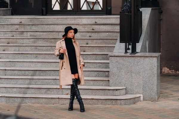 都会の通りの黒い帽子のベージュのコートを着たスタイリッシュな若い女性 女性のストリートファッション Urban Style — ストック写真