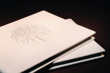 Farklı boyutlarda doğal beyaz deri fotoğraf kitaplarının kompozisyonu. Koyu arkaplan üzerine beyaz kağıt