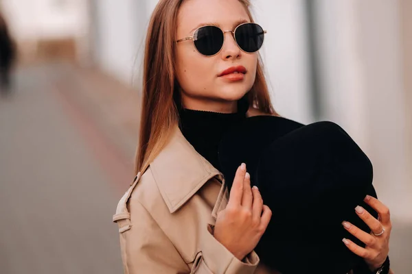Stylish Young Woman Beige Coat Black Hat His Hands Glasses — Stock Photo, Image