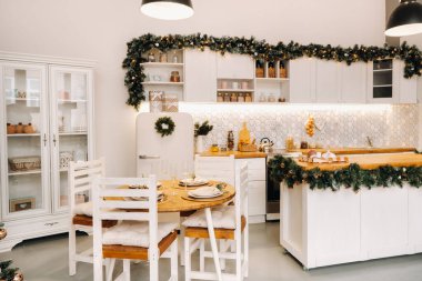 Mutfaktaki Noel sofrası süslemesi, yemekten önce bardaklı ziyafet masası, mevsimlik dekorasyonlar, kristal bardaklar ve dekoratif geyiklerle Noel yemeği masasının yakın çekimi..