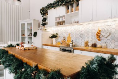 Mutfakta masada kahve, Noel yemeği masasının yakınında mevsimlik dekorasyonlar.