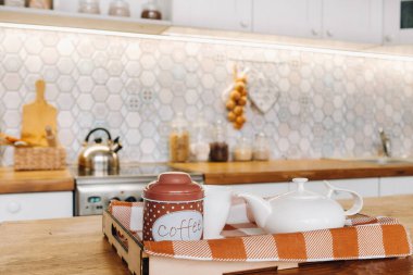 Mutfakta masada kahve, Noel yemeği masasının yakınında mevsimlik dekorasyonlar.