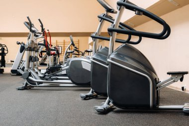 Parlak spor. Spor salonundaki spor aletleri. Sıranın üzerinde farklı ağırlıklar. Antrenörler..