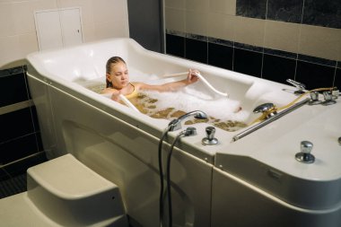 Küçük bir kız mineral banyosunda ameliyat oluyor. Hasta mineral inci banyosu ile su tedavisi görüyor..