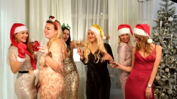 Seksowne kobiety w kapeluszach Mikołaja w kieliszkach do szampana tańczące i śmiejące się. Noworoczne wakacje. Szczęśliwego Nowego Roku — Wideo stockowe