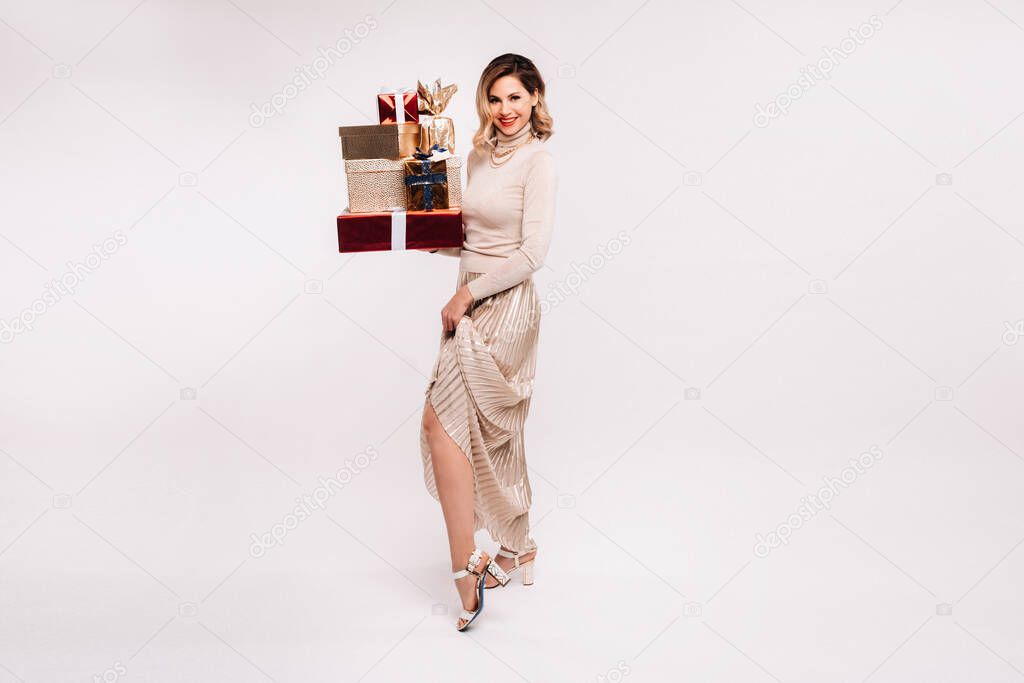 A girl in a skirt and jacket with a lot of gifts in her hands on a white background.