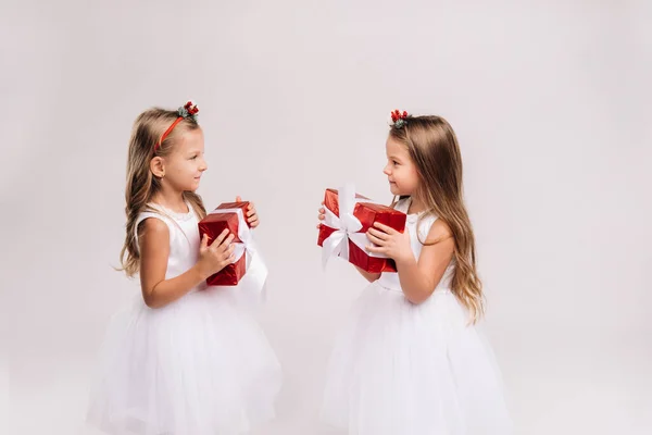 Zwei Kleine Mädchen Weißen Kleidern Mit Weihnachtsgeschenken Auf Weißem Hintergrund — Stockfoto