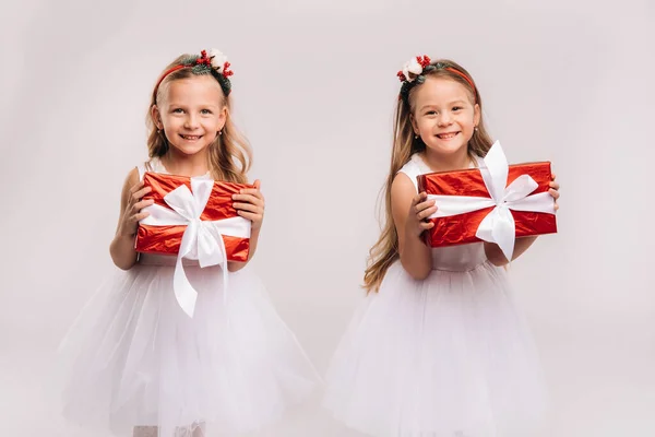 Dos Niñas Vestidos Blancos Con Regalos Navidad Sobre Una Sonrisa —  Fotos de Stock