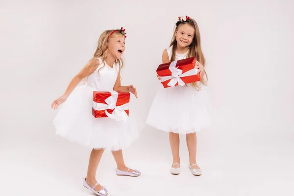 Två Små Flickor Vita Klänningar Med Julklappar Vit Bakgrund Leende — Stockfoto