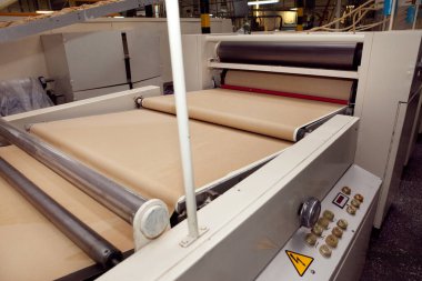 Fabrikada kurabiye yapmak için bir makine. Kurabiye hamurlu taşıyıcı bant.