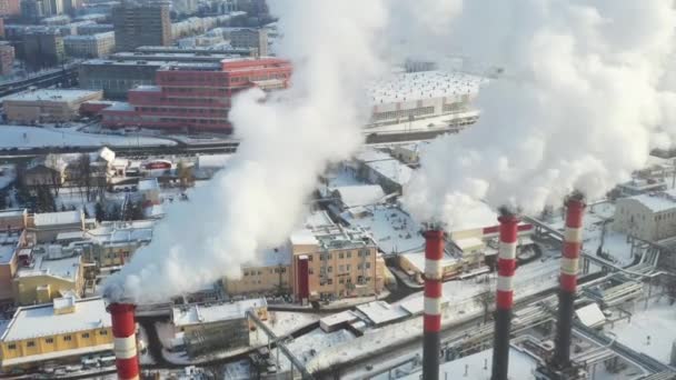 В зимнем городе факторисы дымятся. Концепция загрязнения воздуха. Загрязнение окружающей среды отходами производства — стоковое видео