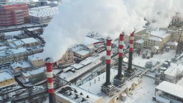 В зимнем городе факторисы дымятся. Концепция загрязнения воздуха. Загрязнение окружающей среды отходами производства — стоковое видео