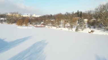Loshitsky Parkı 'nda kışın köprüsü olan gölde bir ada. Minsk, Belarus.