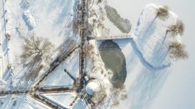 Loshitsky Parkı 'nda kışın köprüsü olan gölde bir ada. Minsk, Belarus.