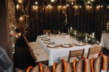 Masada çiçekler, mum ışığında yemek masası dekorasyonu.