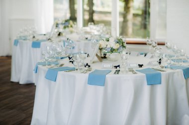 Düğün masası süslemesi. Düğün yemeği için restoran masasının üstünde mavi çiçekler var.
