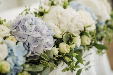 Düğün masası süslemesi. Düğün yemeği için restoran masasının üstünde mavi çiçekler var.