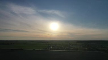 Gün batımında yol kenarındaki araba ve tarlaların olduğu yolun üst görüntüsü. Otoyol yakınındaki tarlalar ve ağaçlar hareket halindeki arabalarla. Belarus.