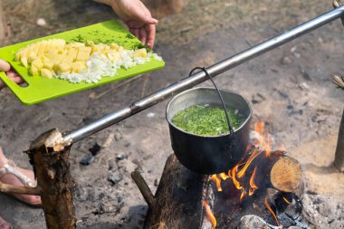 Malzemeleri tencerede ateşte pişirilen çorbanın içine at..