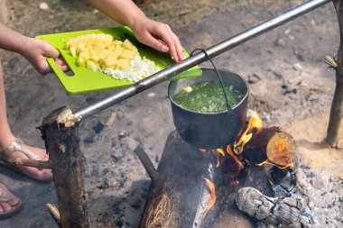 Malzemeleri tencerede ateşte pişirilen çorbanın içine at..