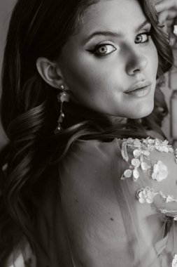 Şatafatlı bir gelinin yakın plan portresi. Sabahları kendi iç mekânında gelinlik giyiyor.