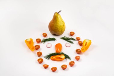 Dilimlenmiş sebzelerden yapılmış bir adamın yüzü ve kafasında beyaz bir armut..