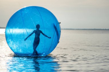 Şişme bir çekiciliği olan, denizde top şeklinde bir kız..