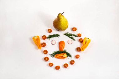 Dilimlenmiş sebzelerden yapılmış bir adamın yüzü ve kafasında beyaz bir armut..