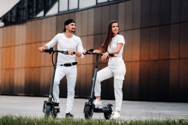 Elektrikli scooterlı bir çift şehirde geziyor, birkaç aşık scooterla geziyor..