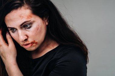 İzole edilmiş gri arka planda siyah elbiseli bir kadın. Kadınlara şiddet.
