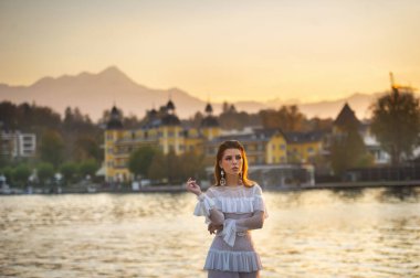 Eski Avusturya şehrinde gün batımında beyaz gelinlik içinde bir gelin..