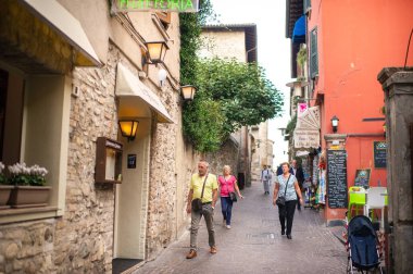 Sirmione, İtalya-9 Ekim 2018: Scaligera kalesi yakınlarındaki Sirmione kasabasında insanlar dinleniyor.