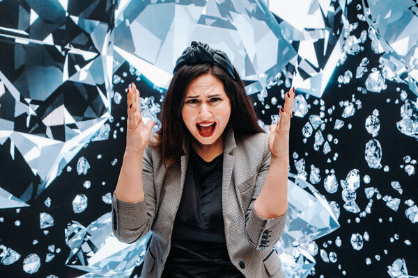 A girl in black pants and a jacket on a background of diamonds.