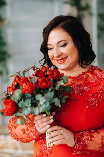Жінка Червоній Сукні Стоїть Тримає Інтер Єрі Букет Червоних Троянд — стокове фото