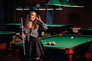 Bilardo kulübünde elinde ıstakayla şapkalı bir kız. Bilardo oyunu..