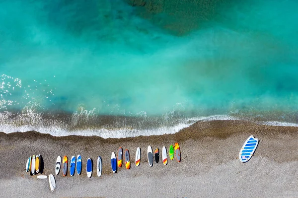 Vista Superior Tablas Surf Colores Tumbadas Caóticamente Una Playa Guijarros — Foto de Stock