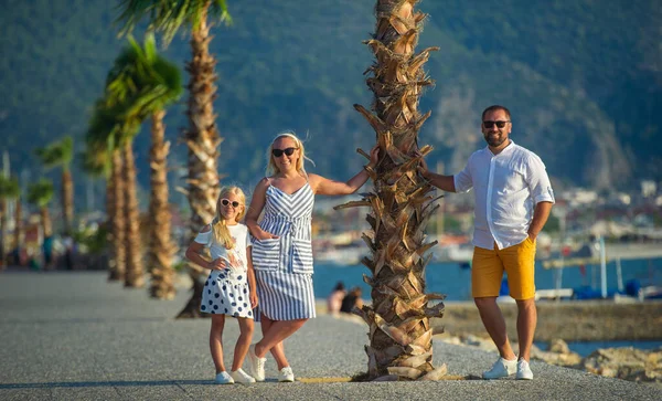 Een Gelukkig Gezin Staat Onder Een Palmboom Aan Het Water — Stockfoto