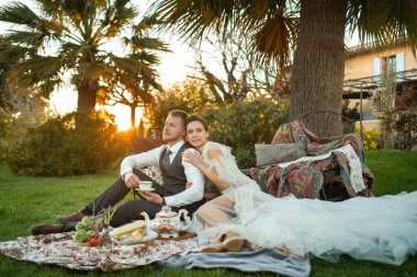 Yeni evlilerin akşam yemeği gün batımında çimenlikte. Fransa 'da bir çift oturur ve gün batımında çay içer..