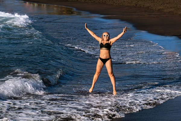 Girl Black Swimsuit Jumps Beach Island Tenerife Atlantic Ocean Spain — Stock Photo, Image