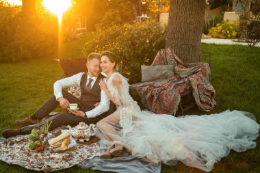 Yeni evlilerin akşam yemeği gün batımında çimenlikte. Fransa 'da bir çift oturur ve gün batımında çay içer..