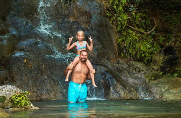 Padre e hija en una cascada en la selva. Viajando en la naturaleza cerca de una hermosa cascada, Turquía — Foto de Stock