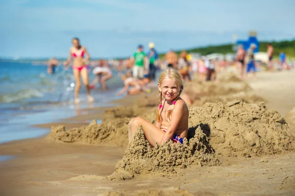 Ένα Χαρούμενο Κορίτσι Κοτσίδες Κάθεται Στην Άμμο Κοντά Στις Ακτές — Φωτογραφία Αρχείου