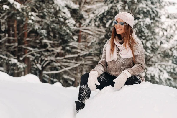 Uma Menina Uma Camisola Óculos Inverno Senta Fundo Coberto Neve — Fotografia de Stock